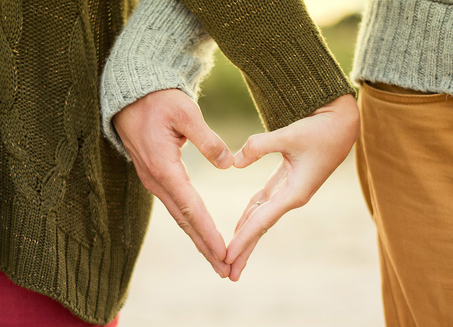 Couple holding their hands in the shape of a heart